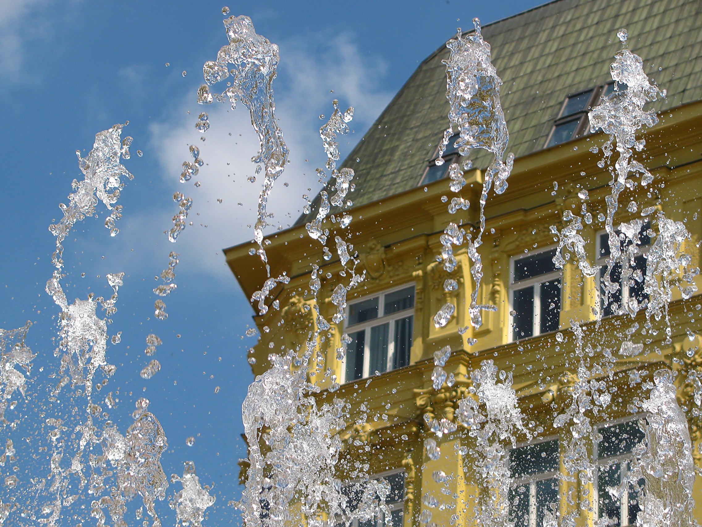 fountain water by yellow building