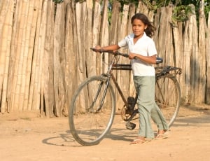girl holding brown bicycke thumbnail