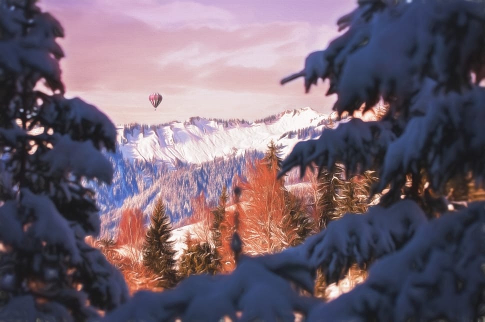 white hot air balloon flying over snowy mountains preview