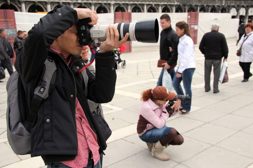 man taking picture using DSLR camera with extended lens preview