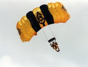 man riding on Army Paraglider during daytime thumbnail