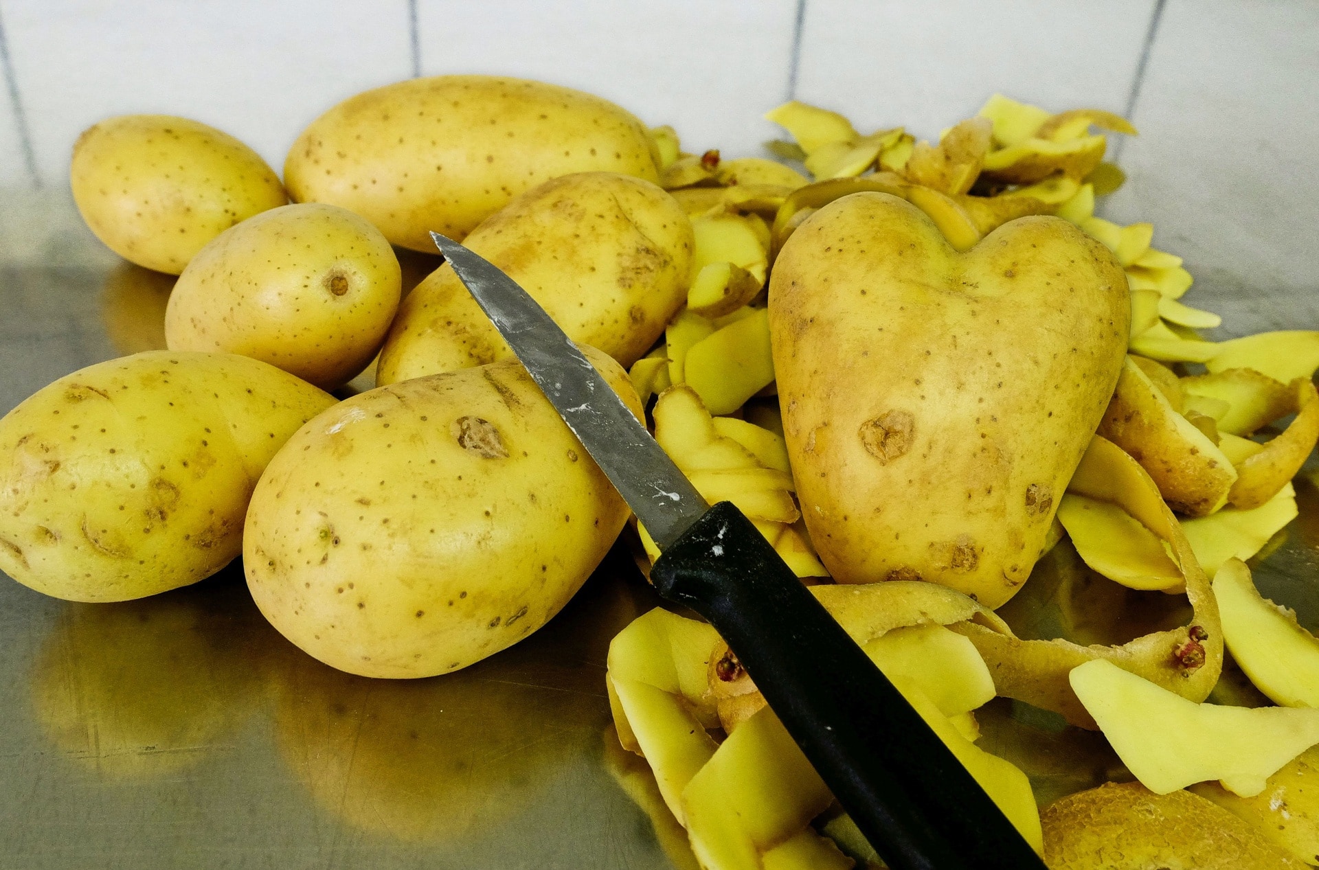 potato with knife on kitchen