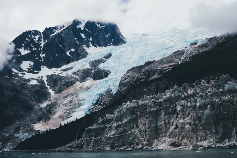 rocky glacier mountain near body of water preview