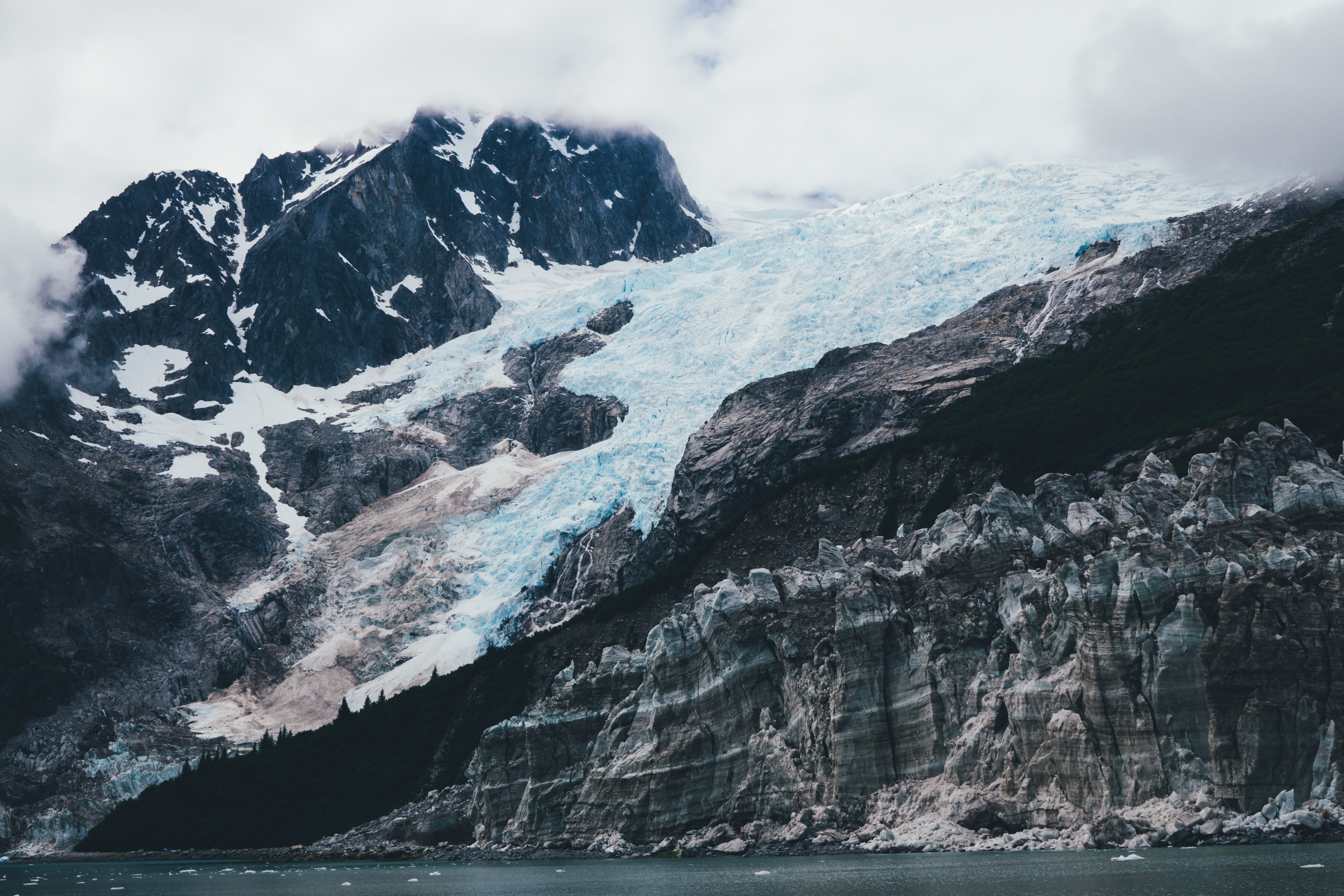 rocky glacier mountain near body of water