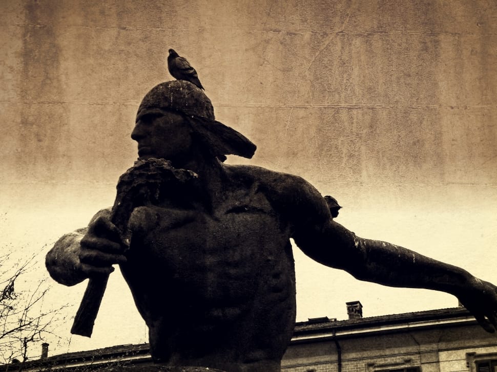 grayscale photo of man holding weapon statue preview