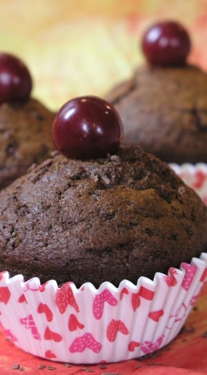 three chocolate muffins with red berry on top thumbnail