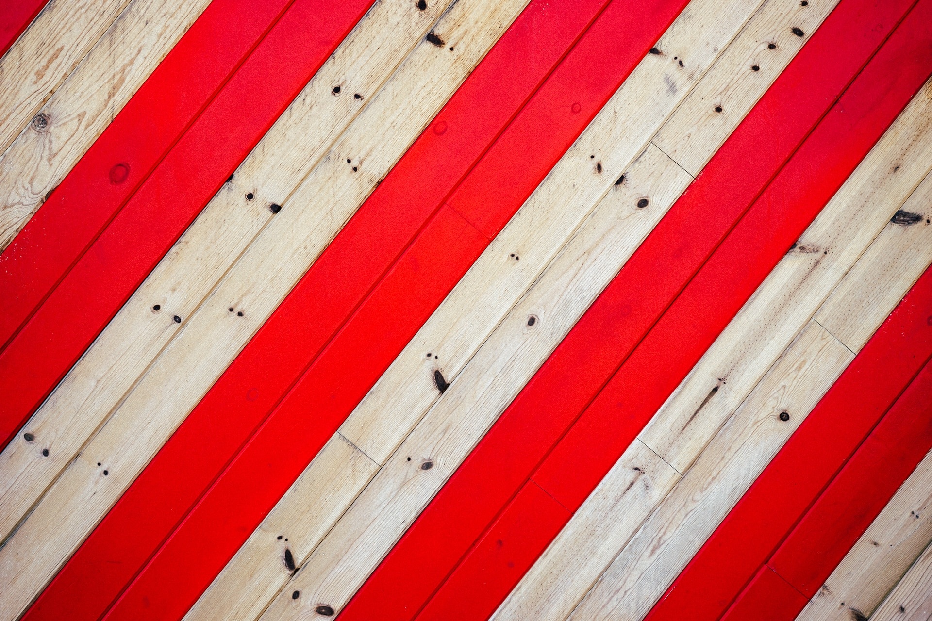 close up photo of red and beige wood floorinbg