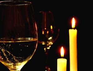 clear wine glass and yellow pillar candles thumbnail