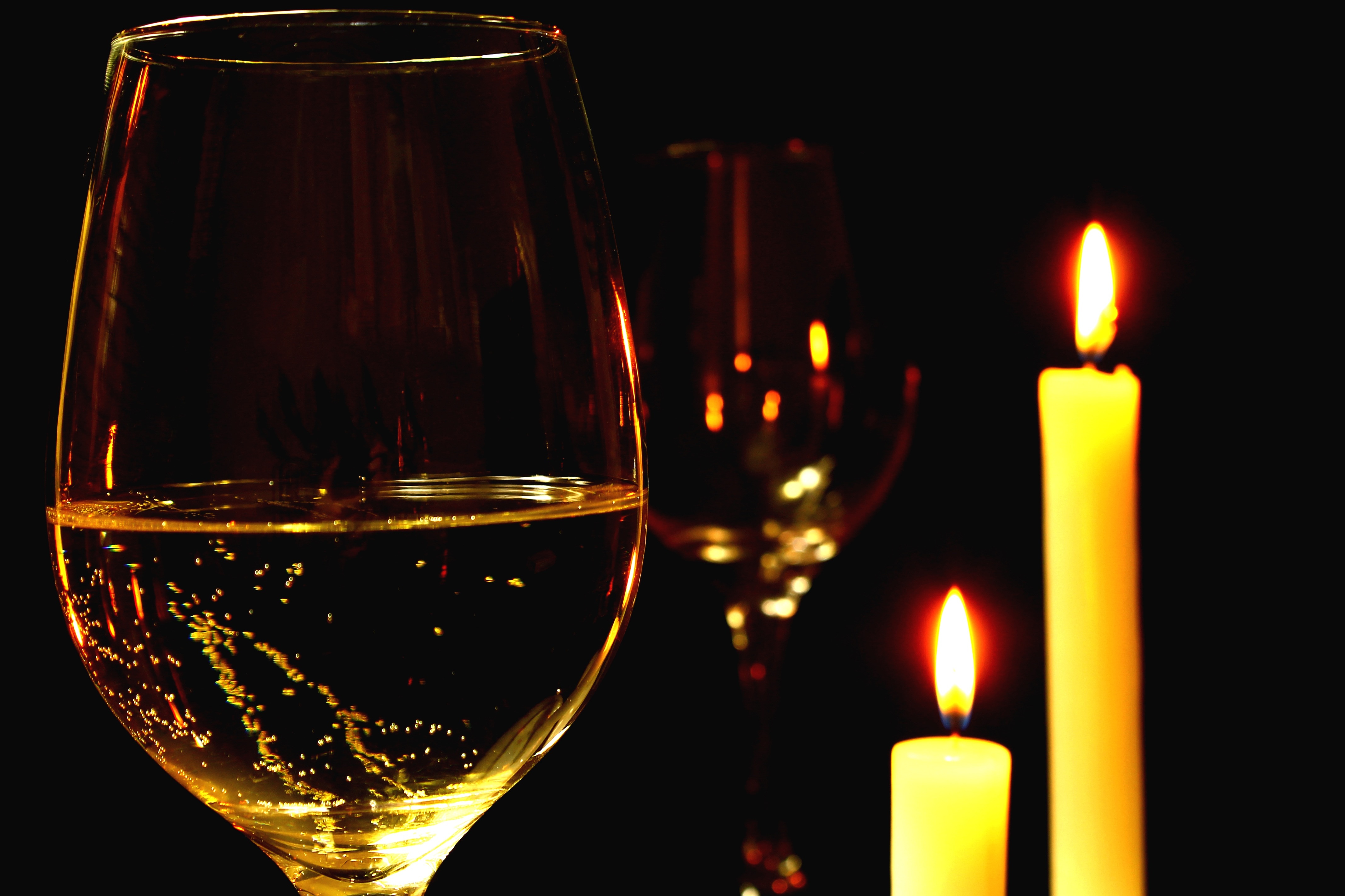clear wine glass and yellow pillar candles