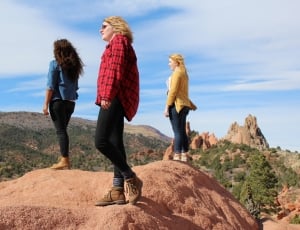 three women standing on rock under blue sky thumbnail