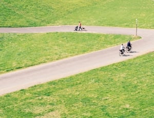 two person cycling in middle of grassfield outdoors during daytime thumbnail