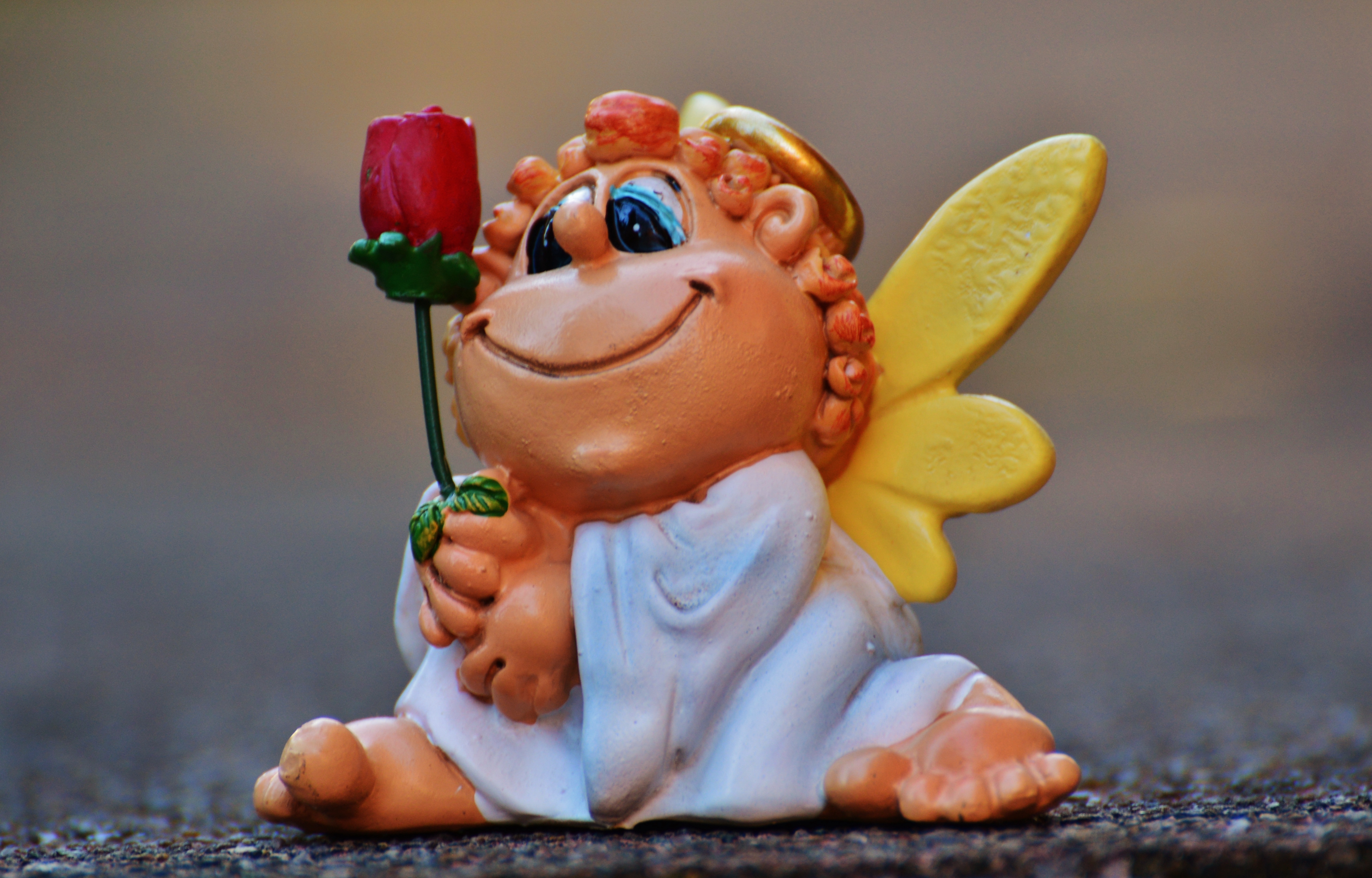 brown haired angel holding rose ceramic figurine