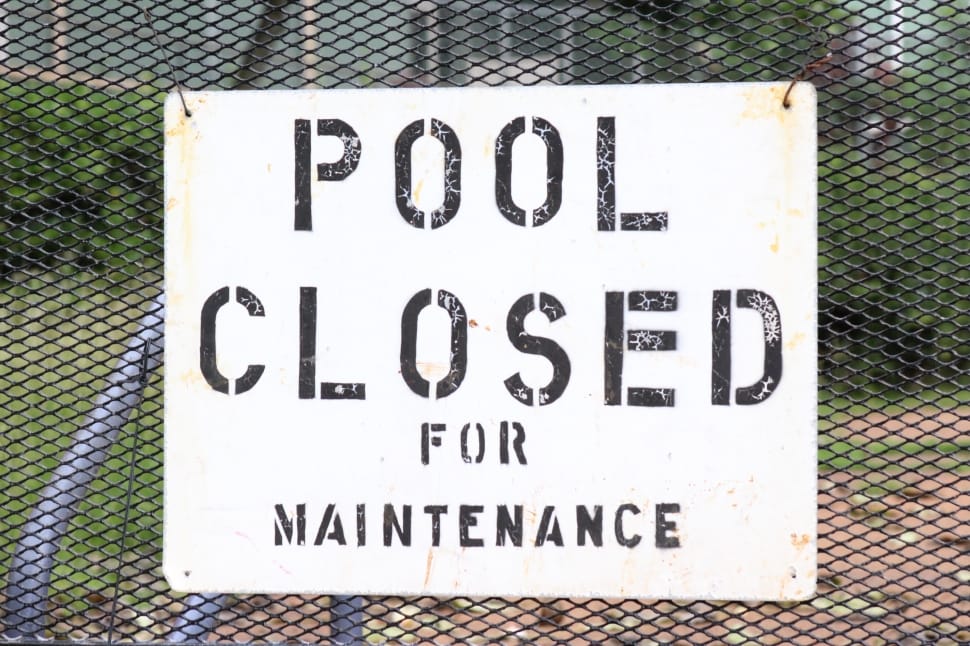 pool closed for maintenance poster hanged on black wired fence preview