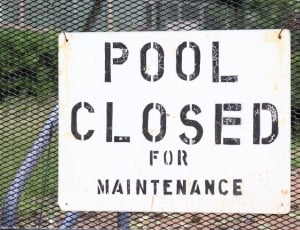 pool closed for maintenance poster hanged on black wired fence thumbnail