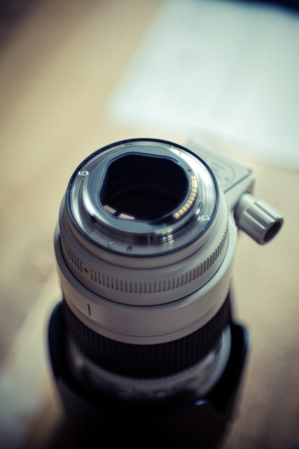 close photography of white camera lens on beige surface preview