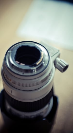 close photography of white camera lens on beige surface thumbnail