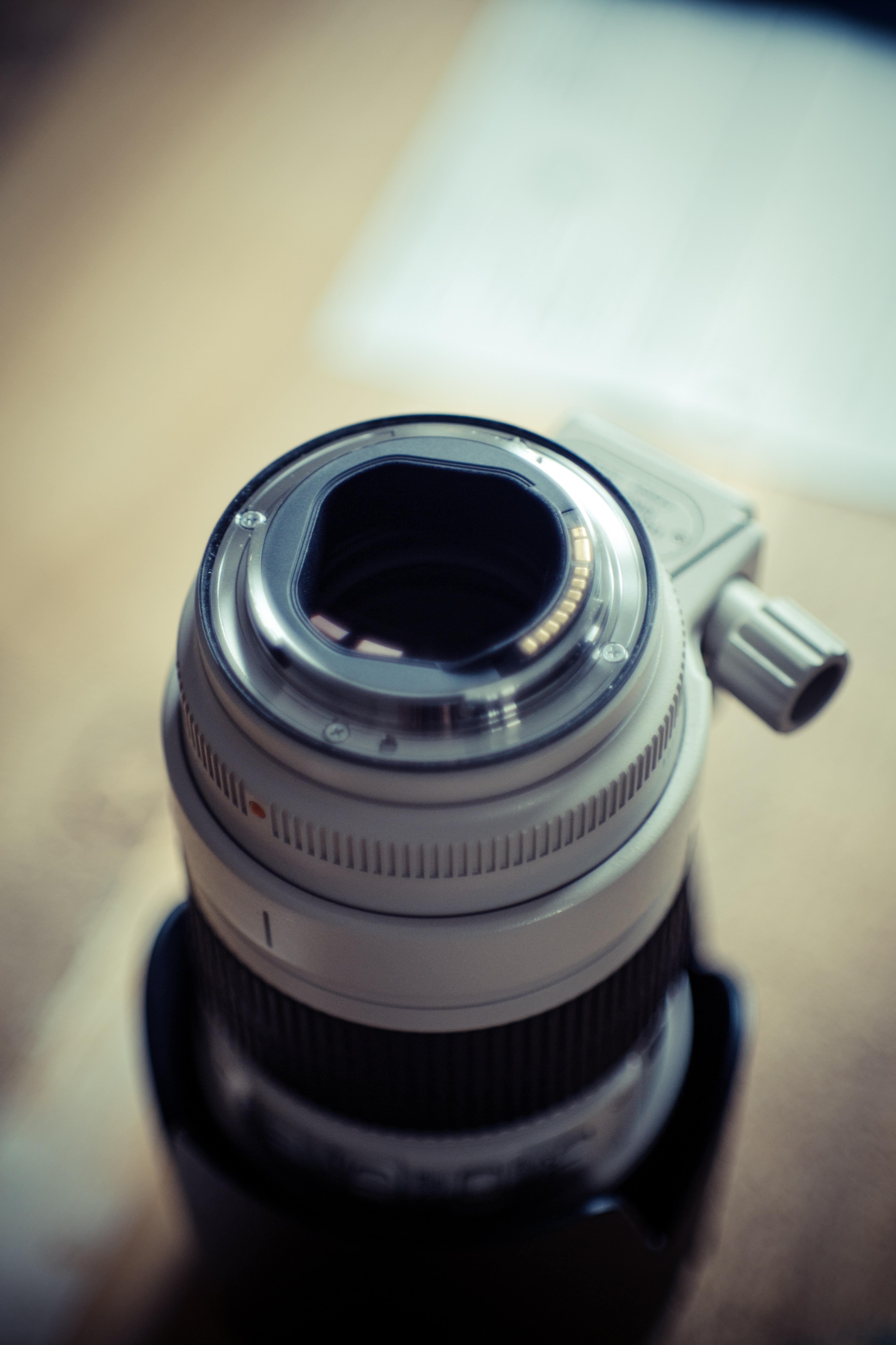 close photography of white camera lens on beige surface