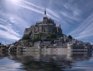 gray castle on body of water during sunny blue sky thumbnail
