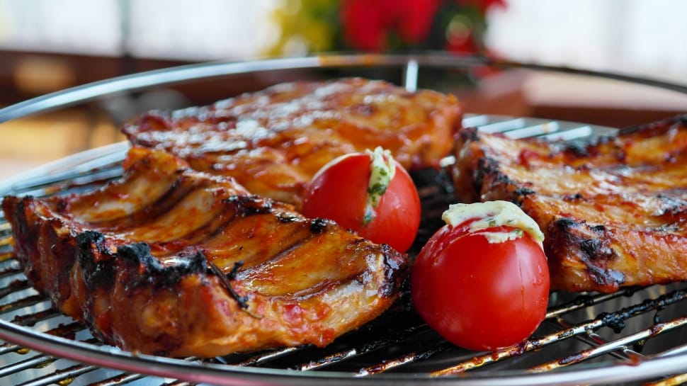 selective focus photo of grill meats and red tomatoes preview
