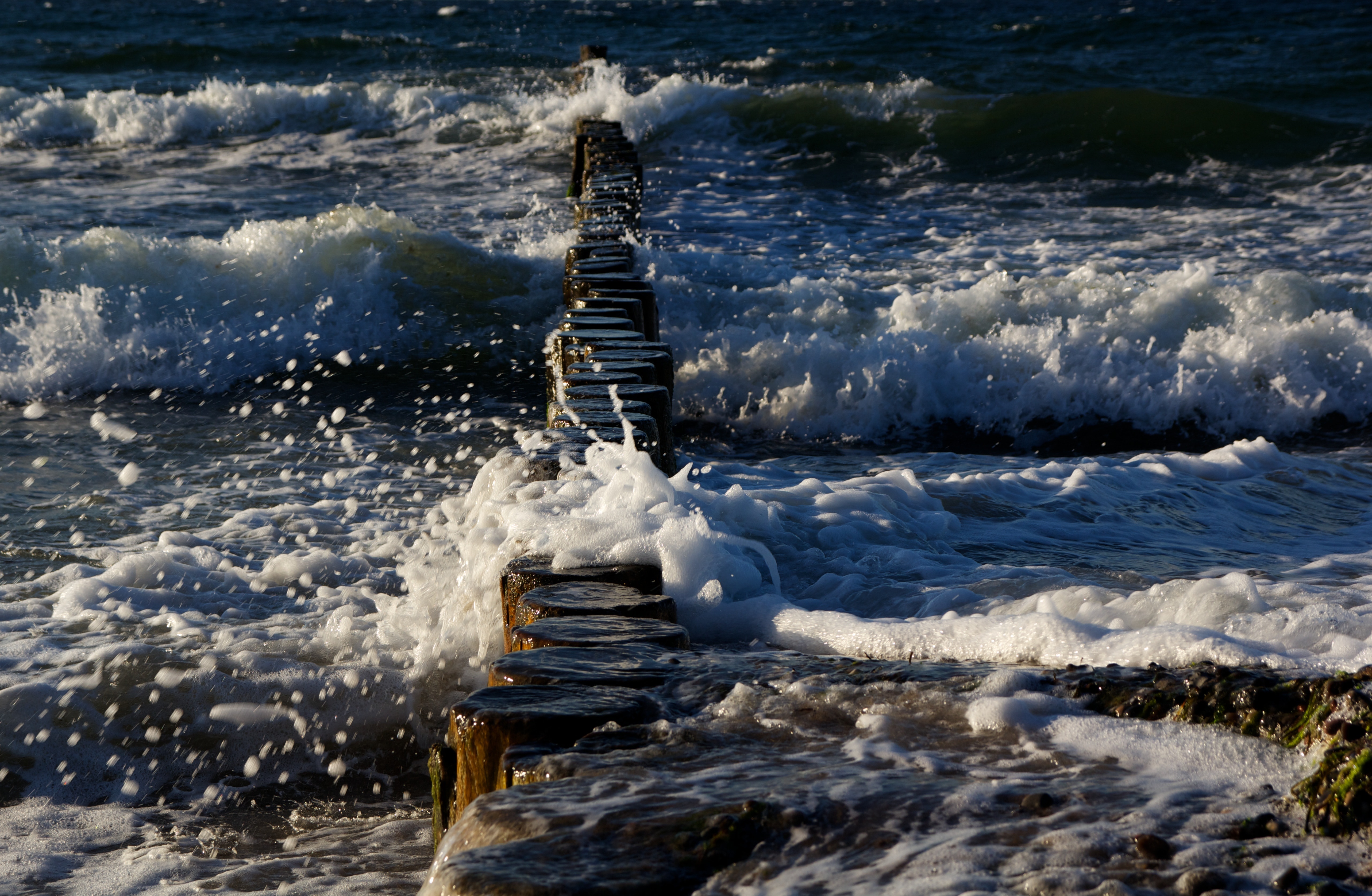wooden dock on body of water with wave
