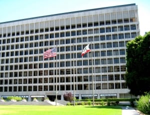 gray concrete building with U.S.A flag in front yard thumbnail