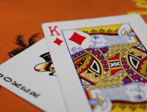 joker and king of diamond playing card on orange surface thumbnail