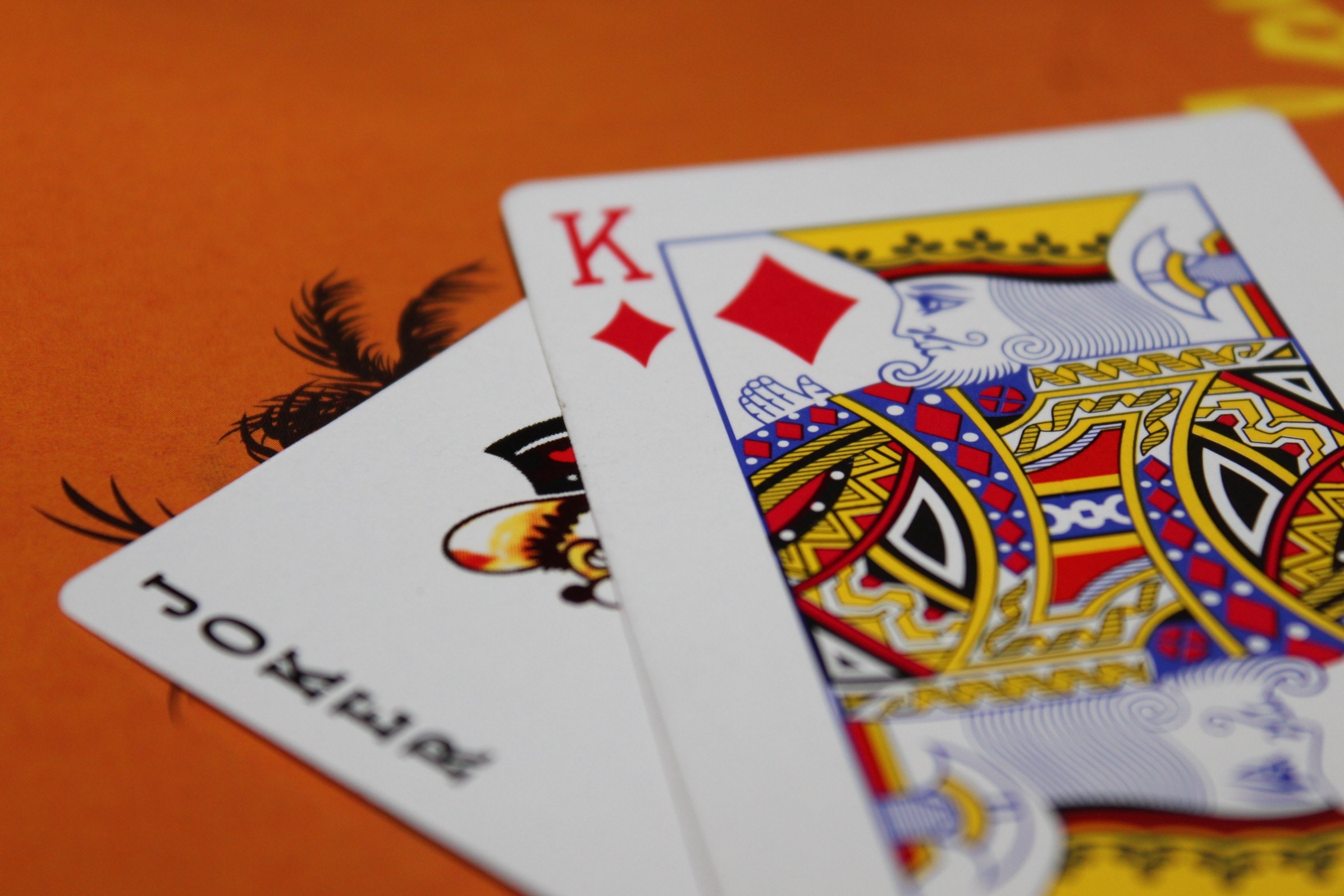 joker and king of diamond playing card on orange surface