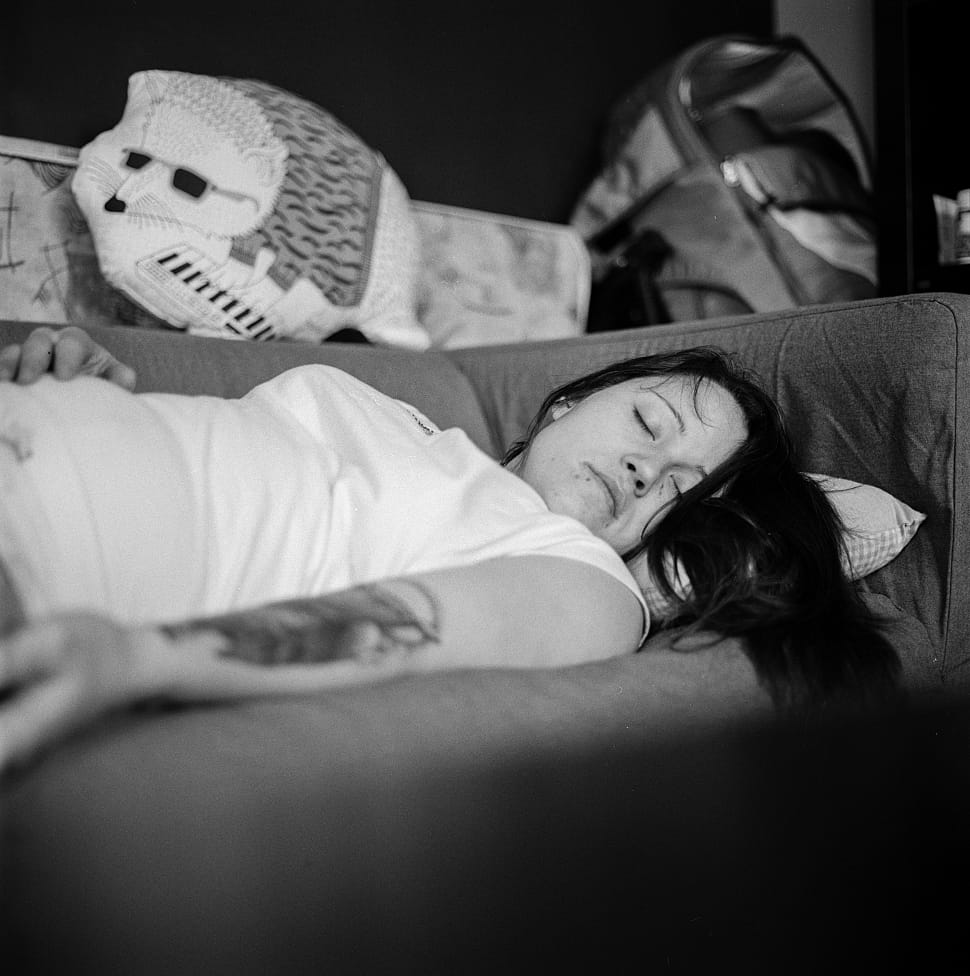 black and white photo of woman sleeping on couch preview