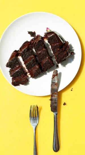 chocolate cake; stainless steel butter spreader and fork and white ceramic plate thumbnail
