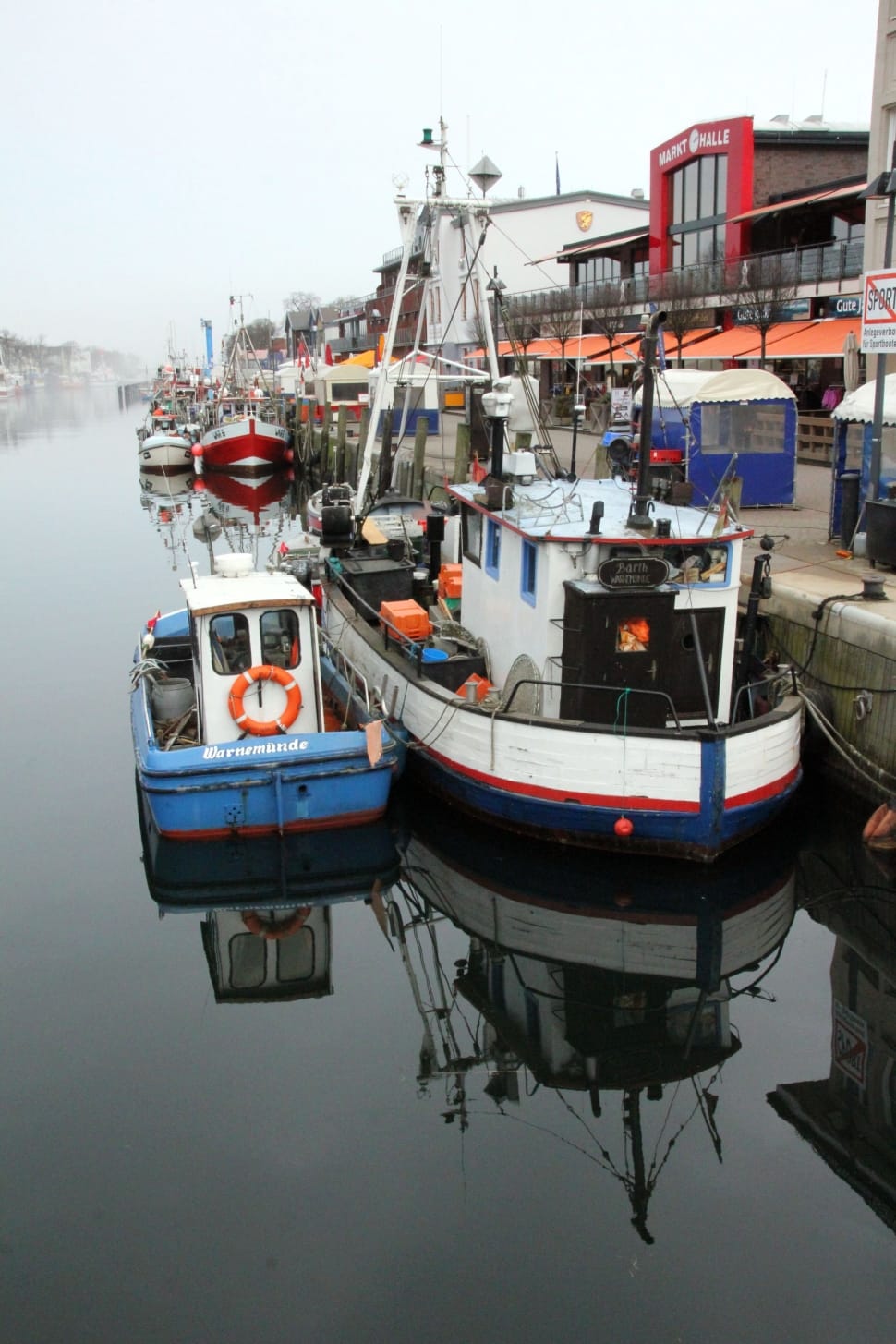 assorted color boats near land under cloudy sky during daytime preview
