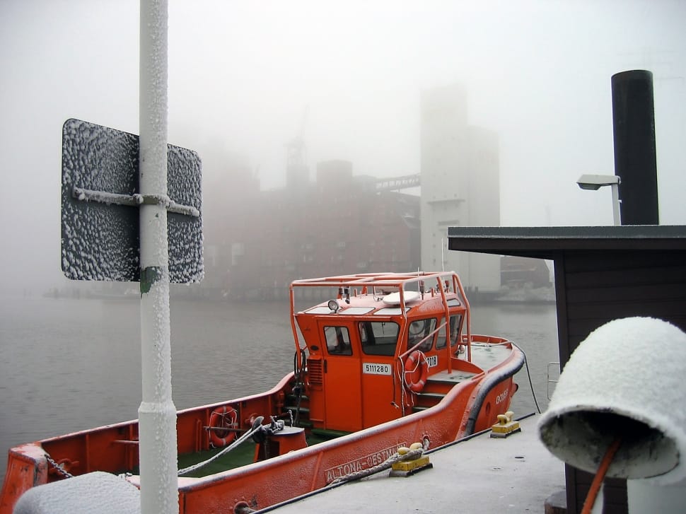 red fishing vessel beside a dock during winter preview