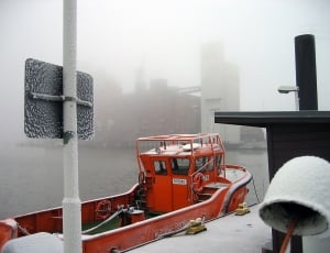 red fishing vessel beside a dock during winter thumbnail