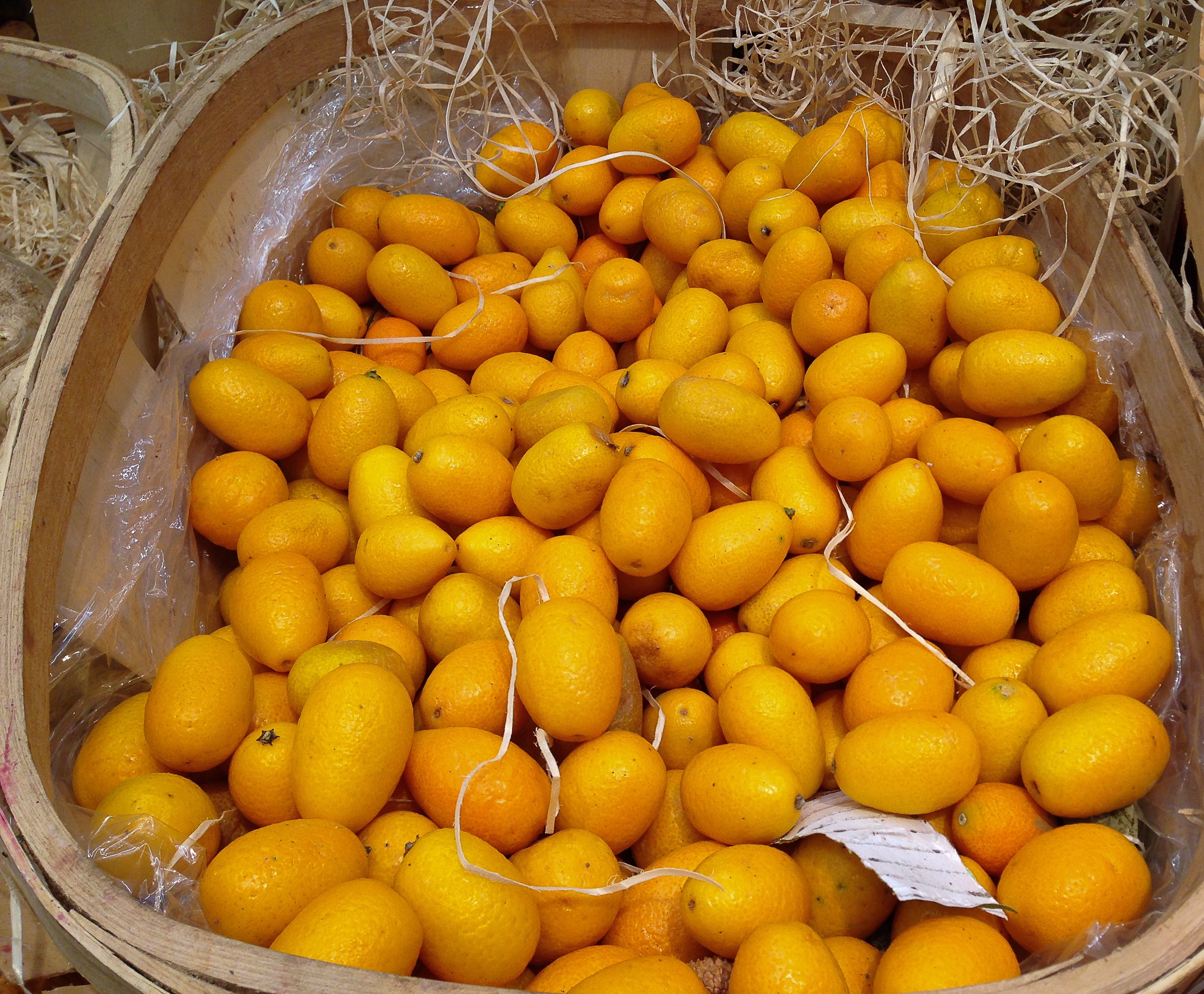 pile of kumquat fruit on brown wicker basket