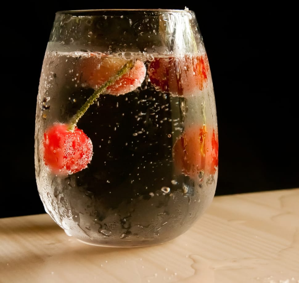 clear drinking glass with water and cherries preview