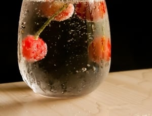 clear drinking glass with water and cherries thumbnail