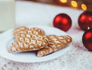 heart shaped cookies on plate near bottle with beside baubles thumbnail