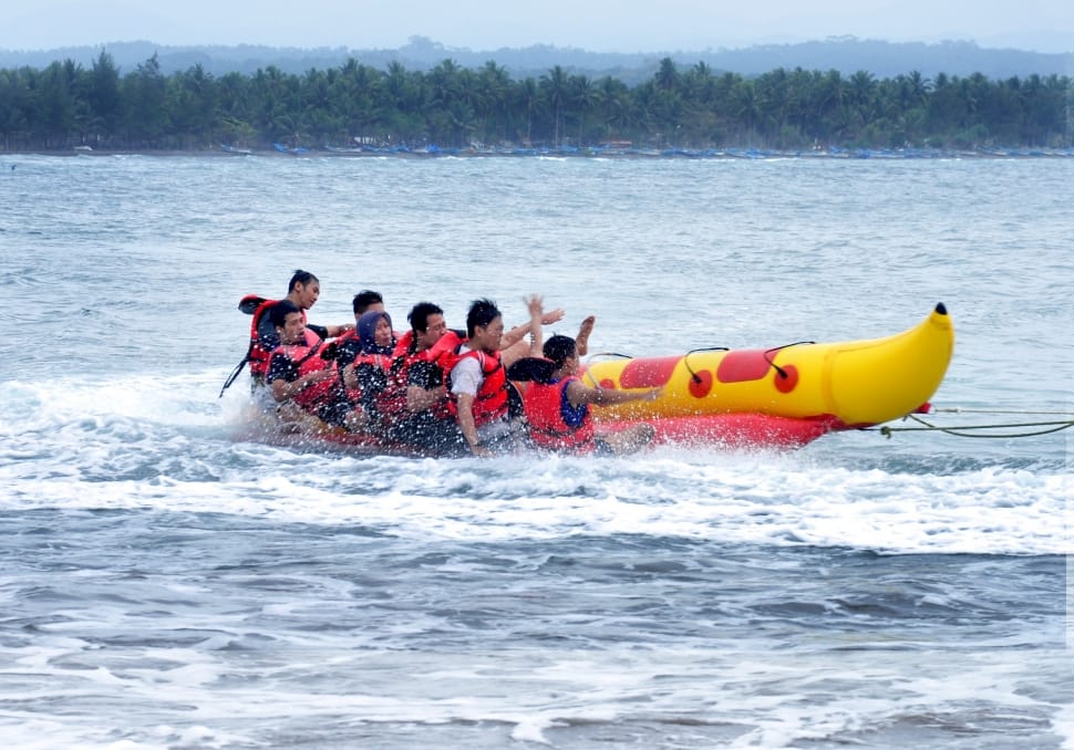 people riding on banana boat during daytime preview
