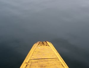 blue body of water under yellow wooden boat thumbnail
