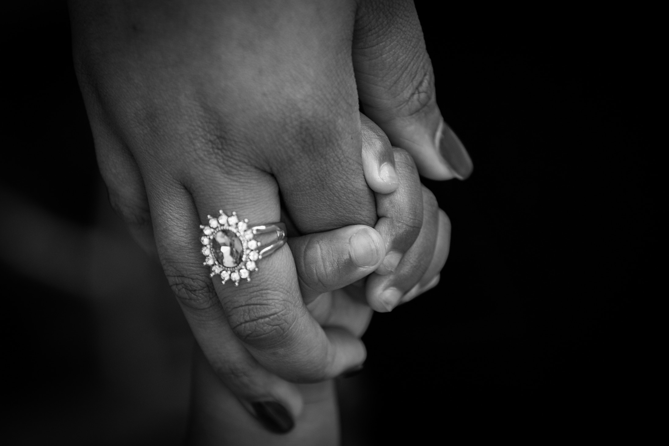 mother with silver diamond rimg holding baby's hand