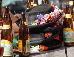 3 black fedora hat surrounded by brown lager bottles thumbnail