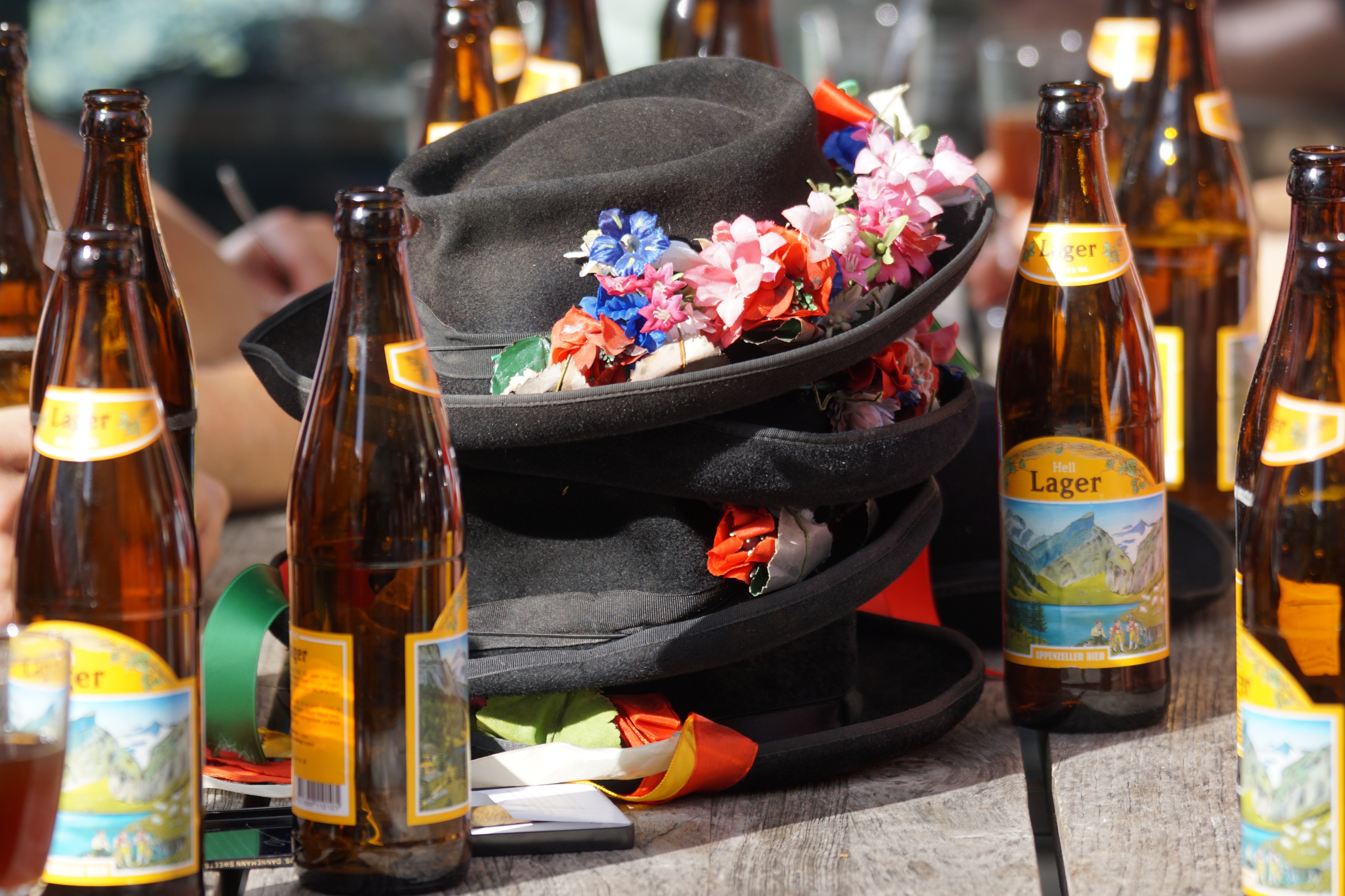3 black fedora hat surrounded by brown lager bottles