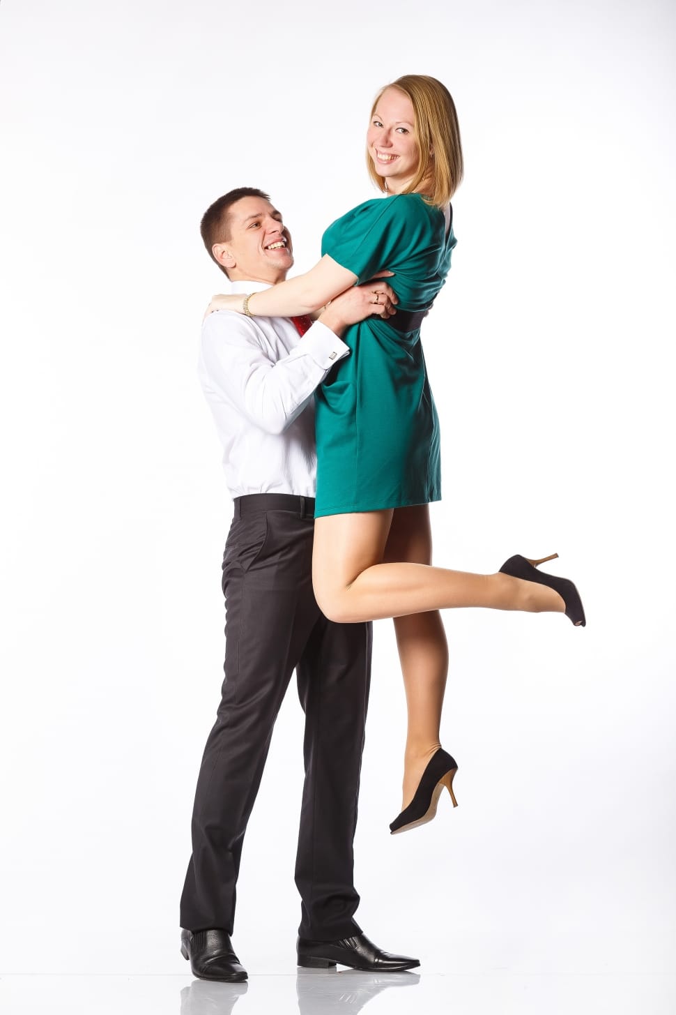 man lifting woman in green mini dress with white as background preview