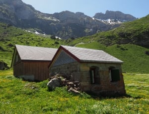 2 brown houses near mountain thumbnail