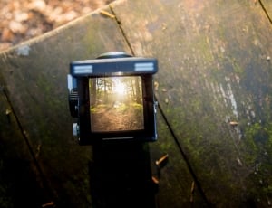 black digital camera on brown wooden surface thumbnail