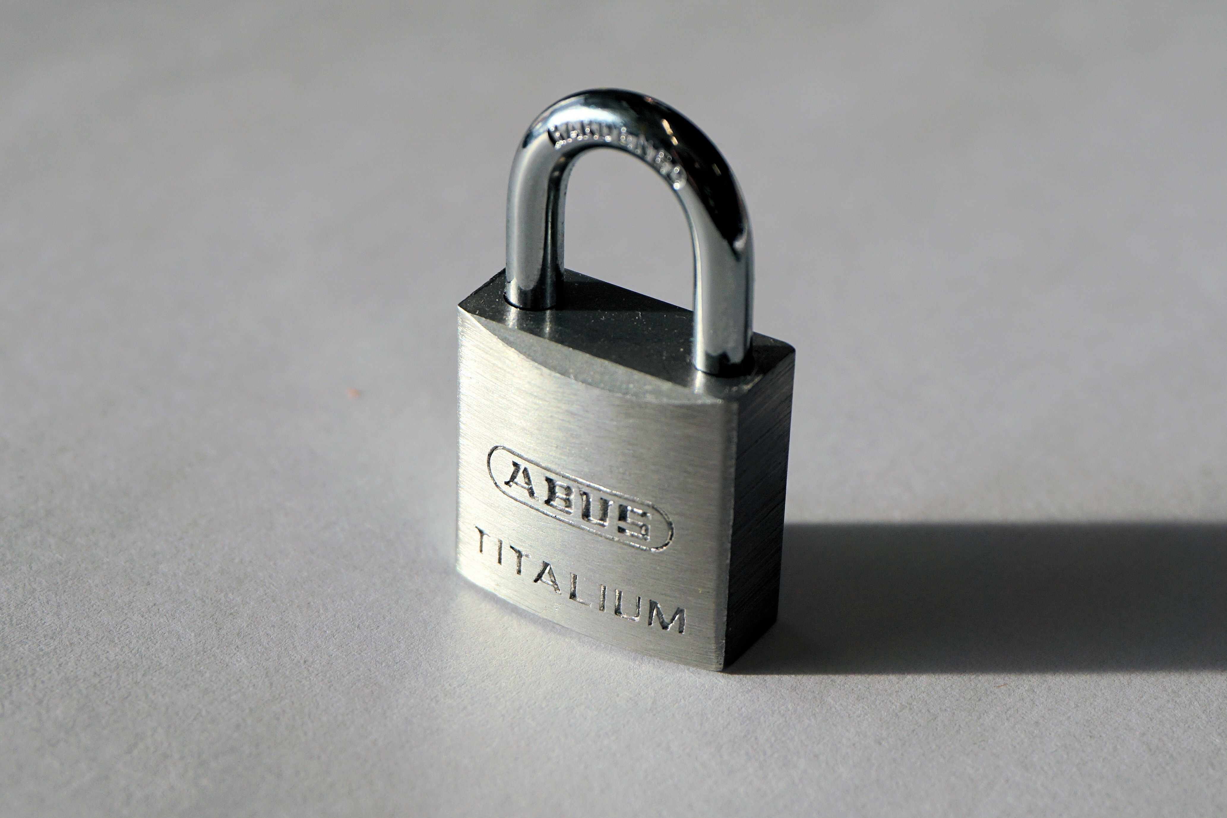 close photo of  Ahue padlock on gray surface