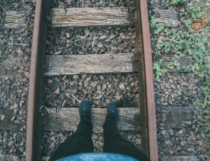 human standing on railways during daytime thumbnail