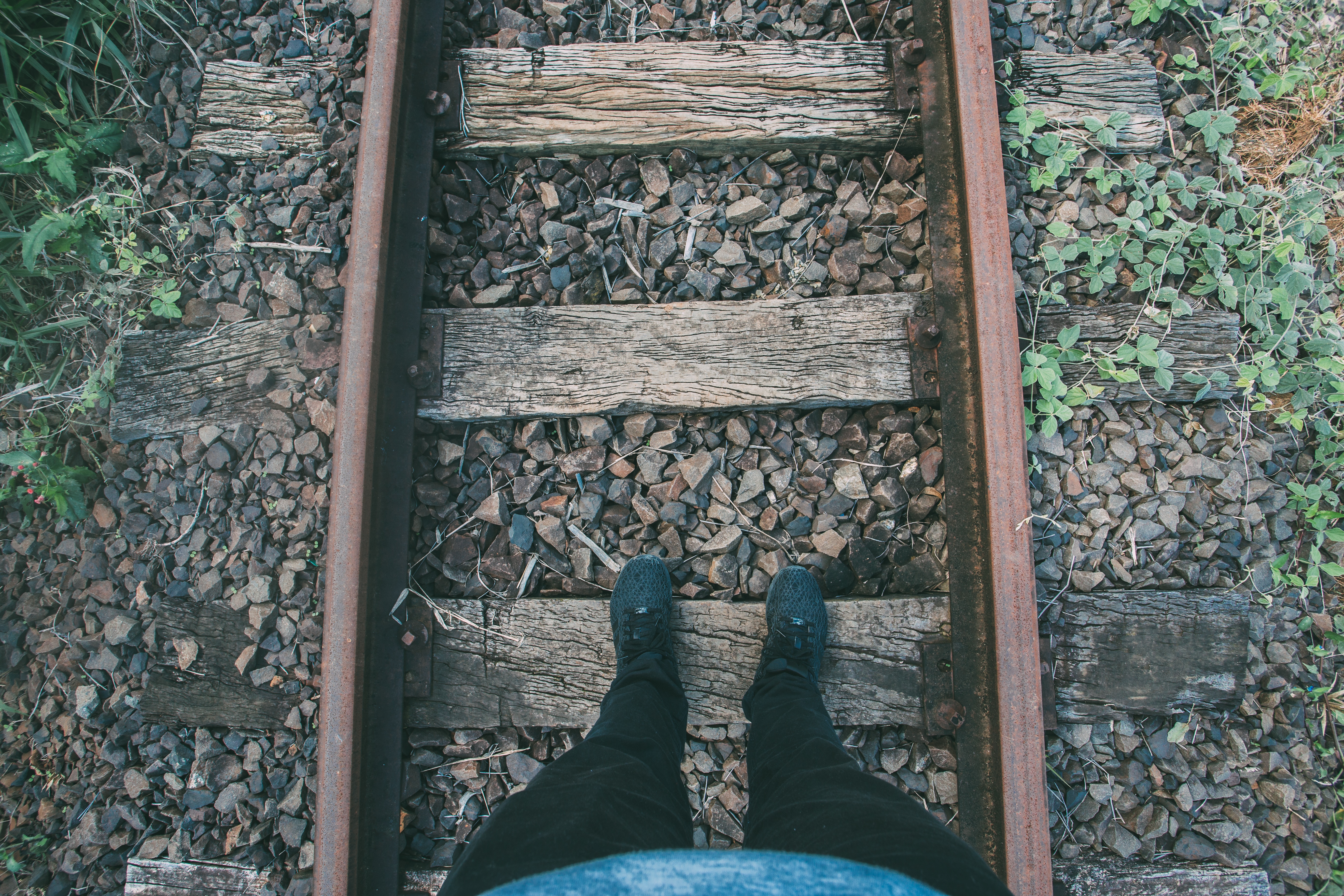 human standing on railways during daytime