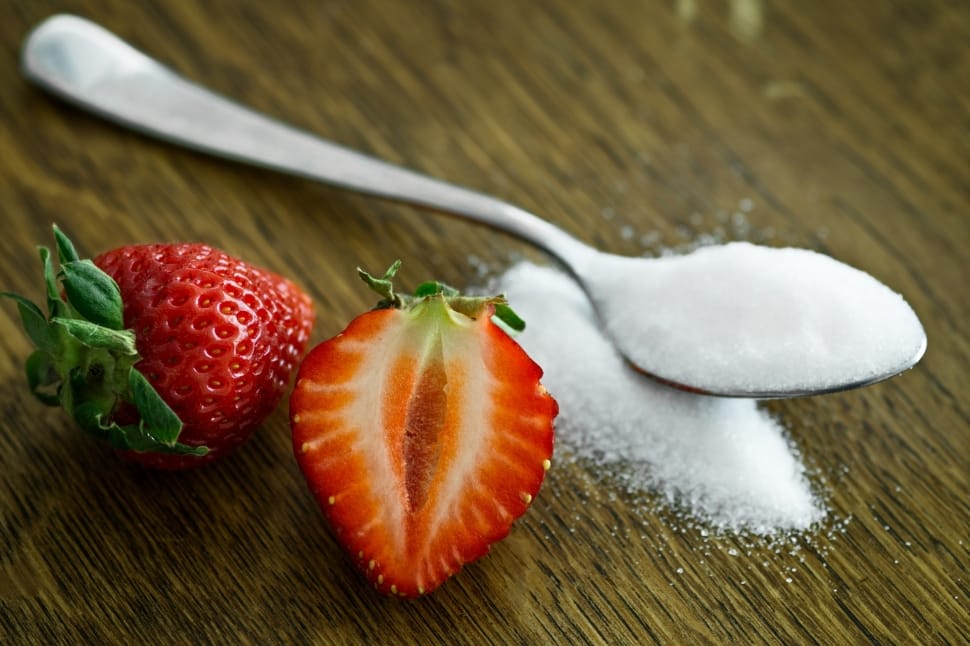 stainless steel spoon with sugar and red sliced strawberry preview