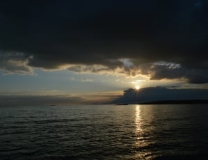 body of water under cloudy sky during sunset thumbnail