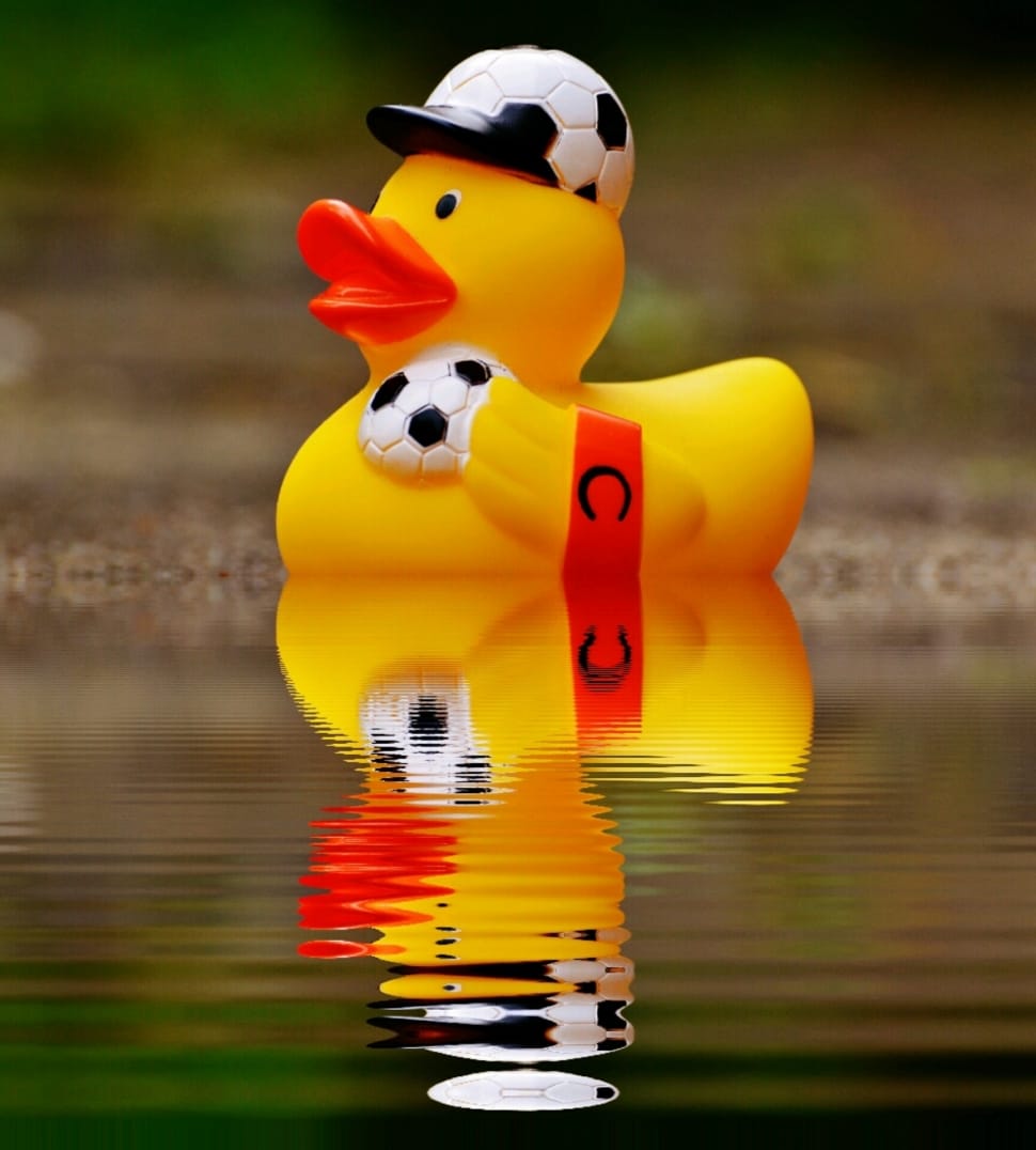 shallow focus photography of soccer player rubber ducky on body of water preview